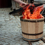 Es wird das Ausfeuern eines Pflanzkübels aus Holz während des Produktionsprozesses dargestellt.