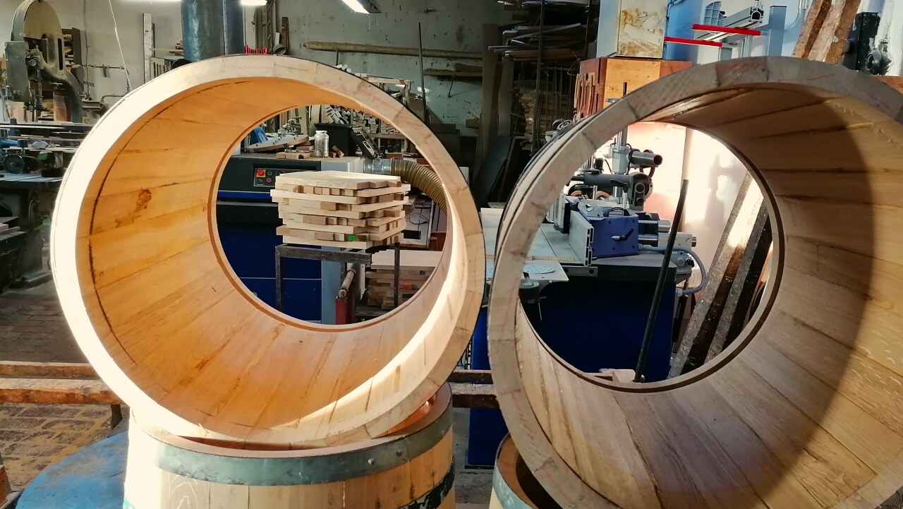 Blick durch zwei Pflanzkuebel ohne Boden in die Boettcherwerkstatt